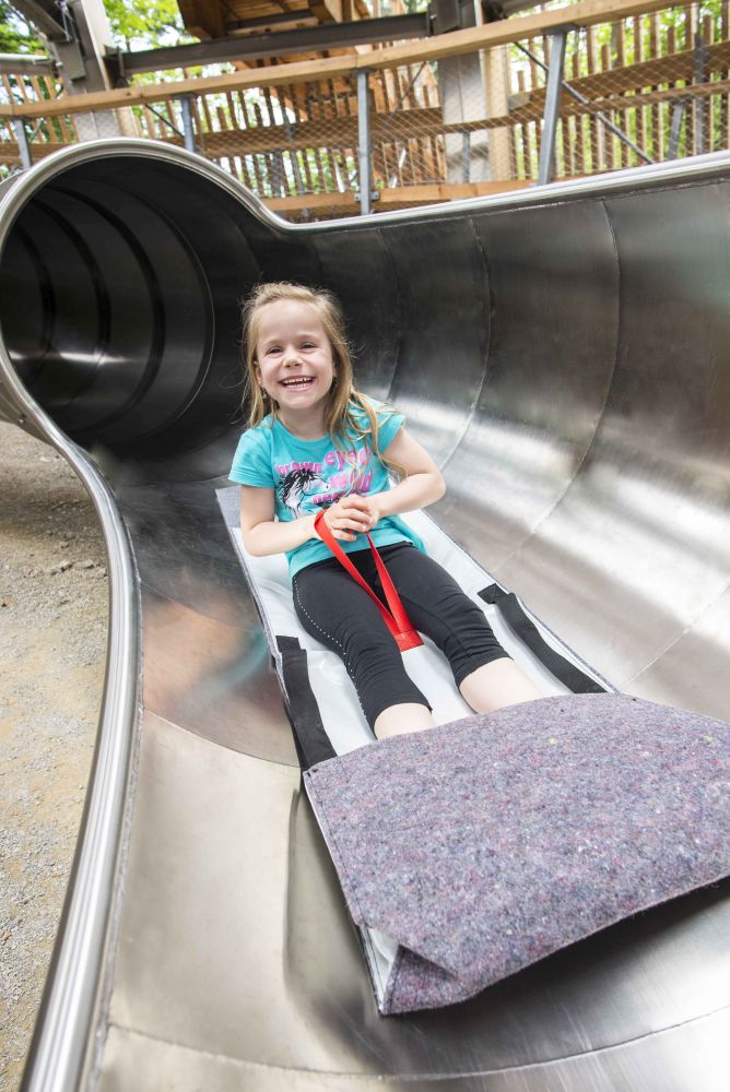 Mädchen rutscht in Sitzmatte auf einer Rutsche