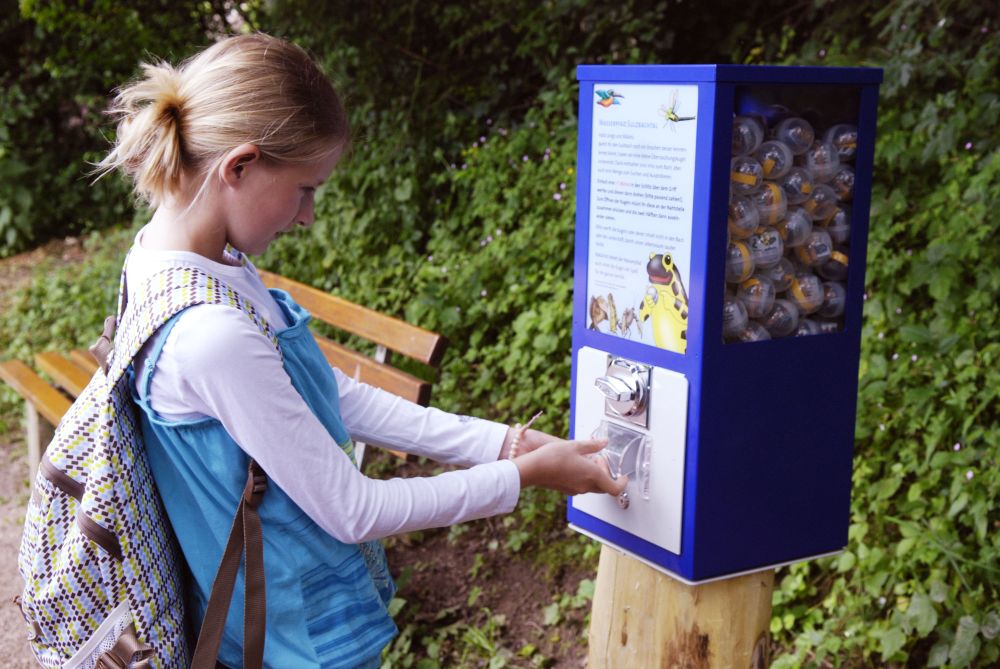 Ein Mädchen bedient einen Automaten.