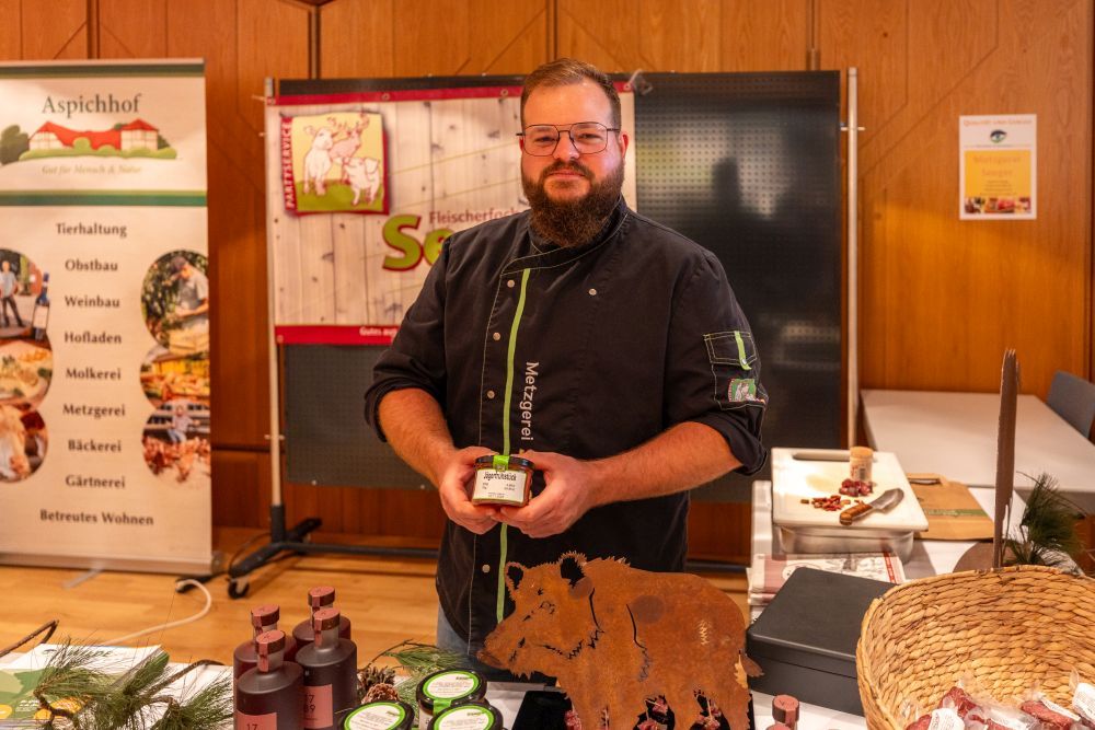 Ein Mann präsentiert an seinem Stand ein Wildschwein-Produkt.