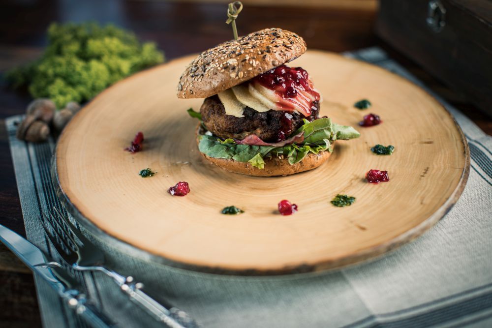 Burger auf einem runden Baumstammring serviert