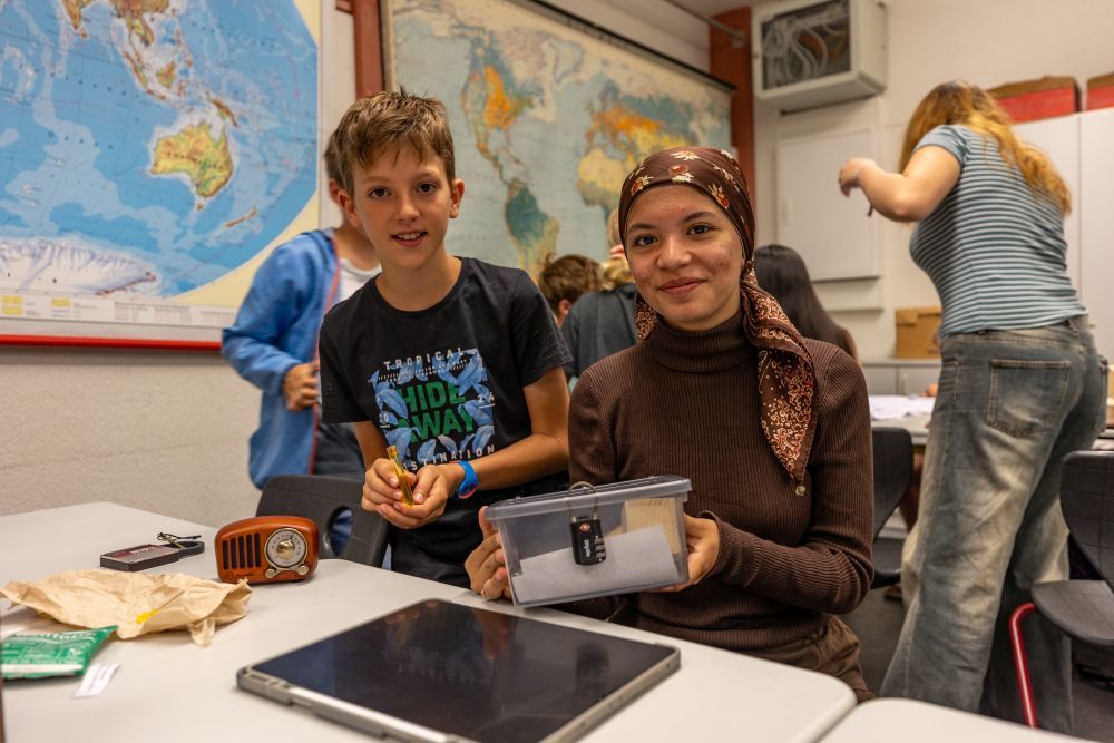 Ein Mädchen und ein Junge basteln an einer Escape Box.