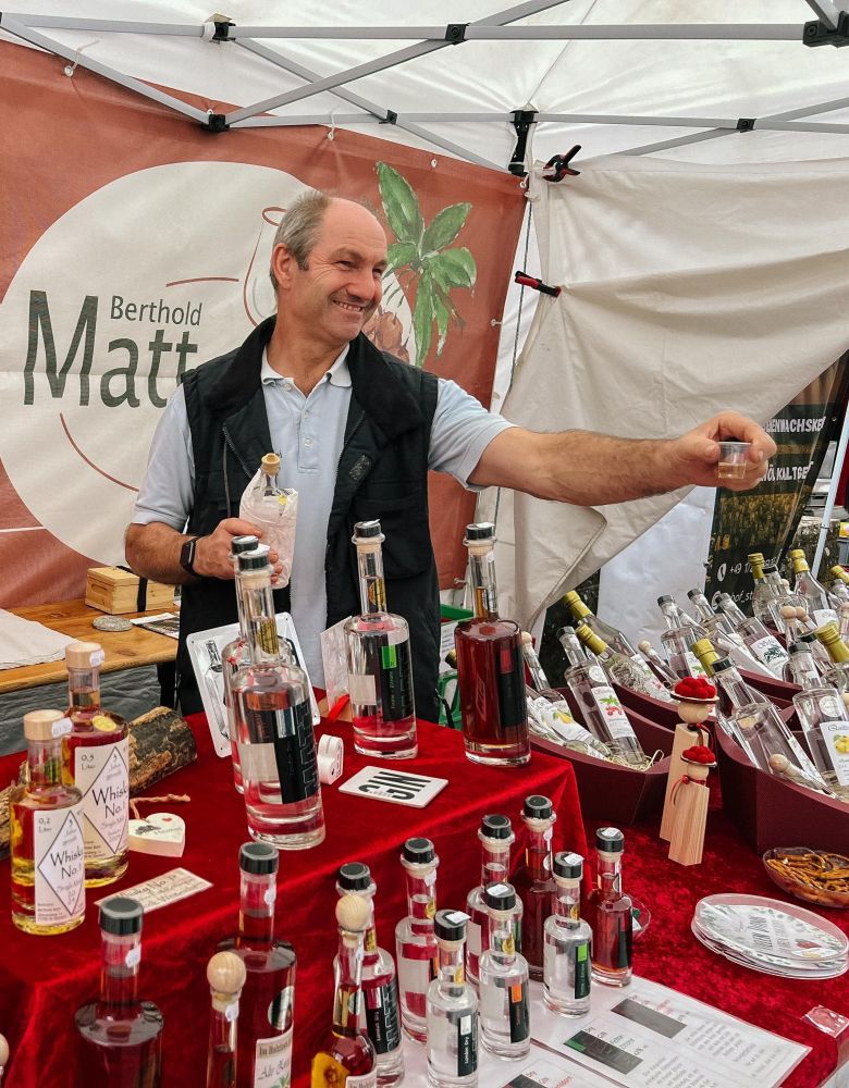 Ein Mann bietet einen Schnaps an