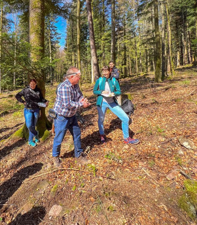 Eine Gruppe von Menschen steht im Wald. 