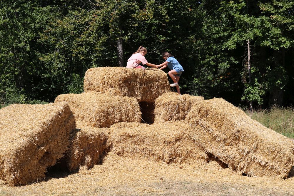 Zwei Mädchen steigen auf Heuballen.