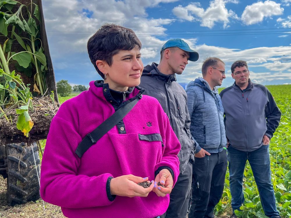 Eine Frau hält humusreiche Erde in den Händen.