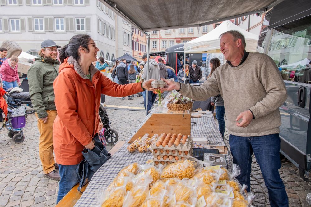 Ein Mann gibt einer Frau eine Eierschachtel.