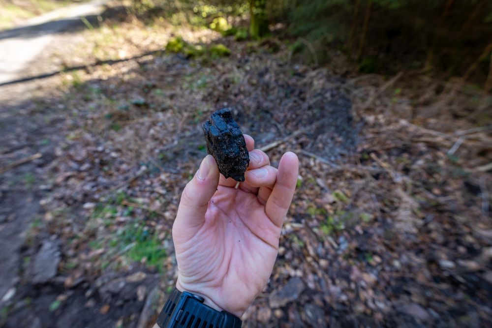 ein schwarzer Stein in einer Hand