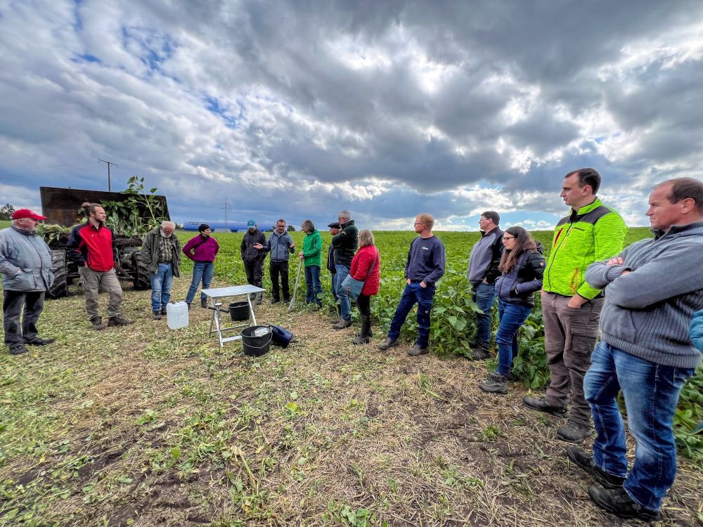 Menschen stehen auf einem Acker