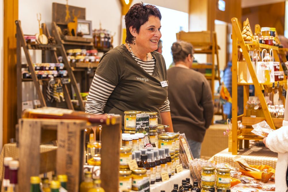 Eine Frau steht an einem Stand mit Honig-Produkten.