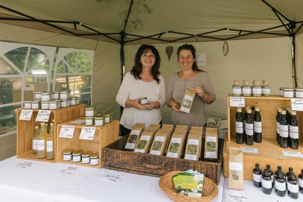Zwei Beschickerinnen präsentieren ihre Kräuter-Produkte an ihrem Stand.