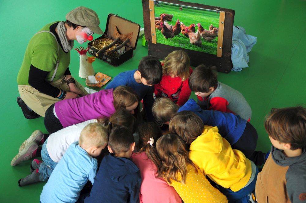 Eine Gruppe von Kindern beugt sich über etwas.