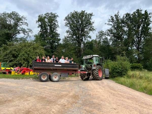 Im Anhänger eines Traktors sitzen Menschen