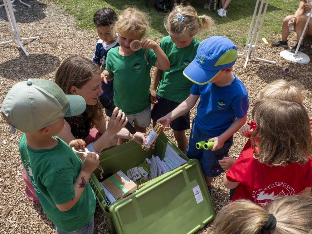 Eine Frau erklärt Kindern die Inhalte der Naturpark-Entdeckerkiste.