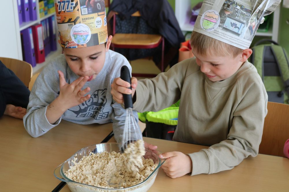 Zwei Jungs rühren in einer Schüssel Haferflocken und Milch zusammen.
