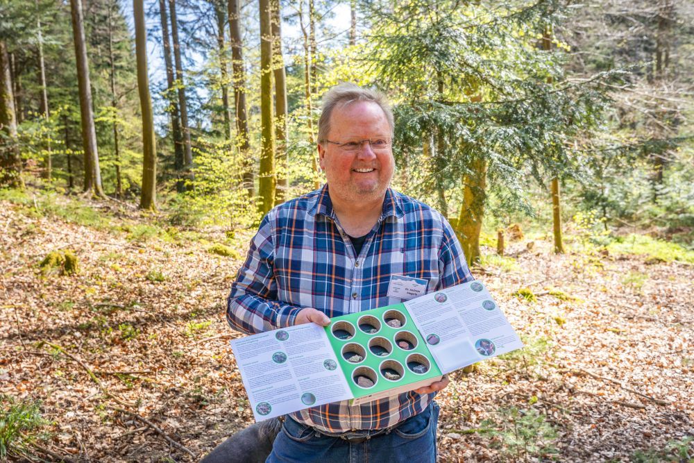 Ein Mann präsentiert eine aufgeklappte Geo-Box.